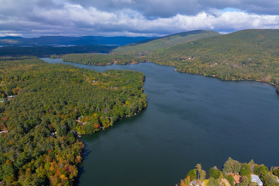 A large lake surrounded by dense forests and hills.