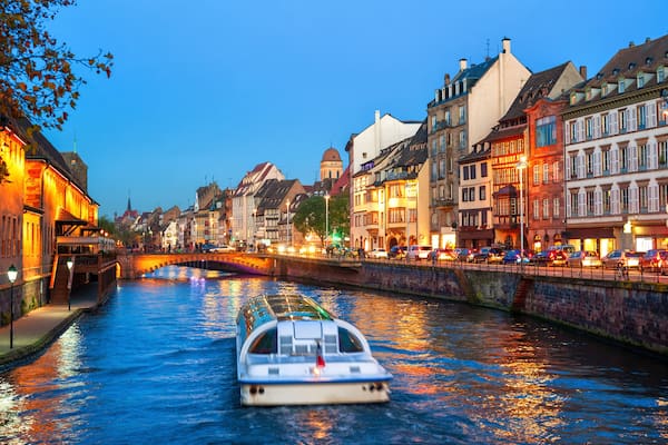 Ein Fluss mit einem Boot, historischen GebĂ€uden und einer BrĂŒcke.