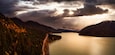 A lake surrounded by mountains with a road along the shore.