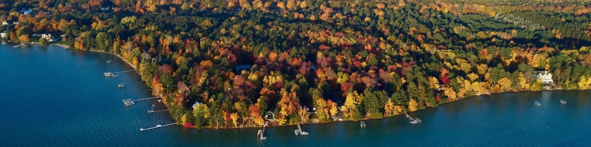 Aerial view of a lake with patches of bright colorful autumn trees in Greenwood