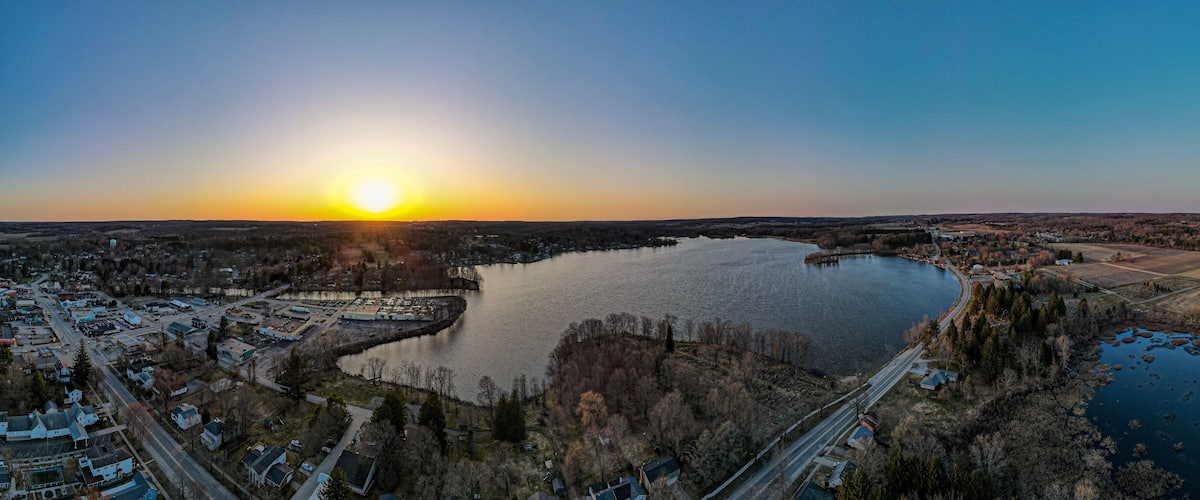 A sunset over a lake surrounded by residential areas and a bridge.