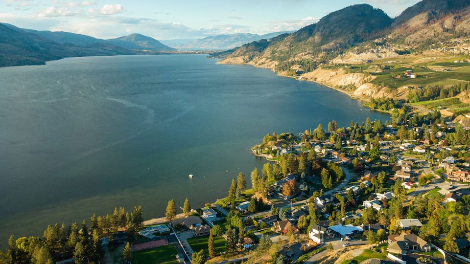 A lake surrounded by mountains and a residential area.
