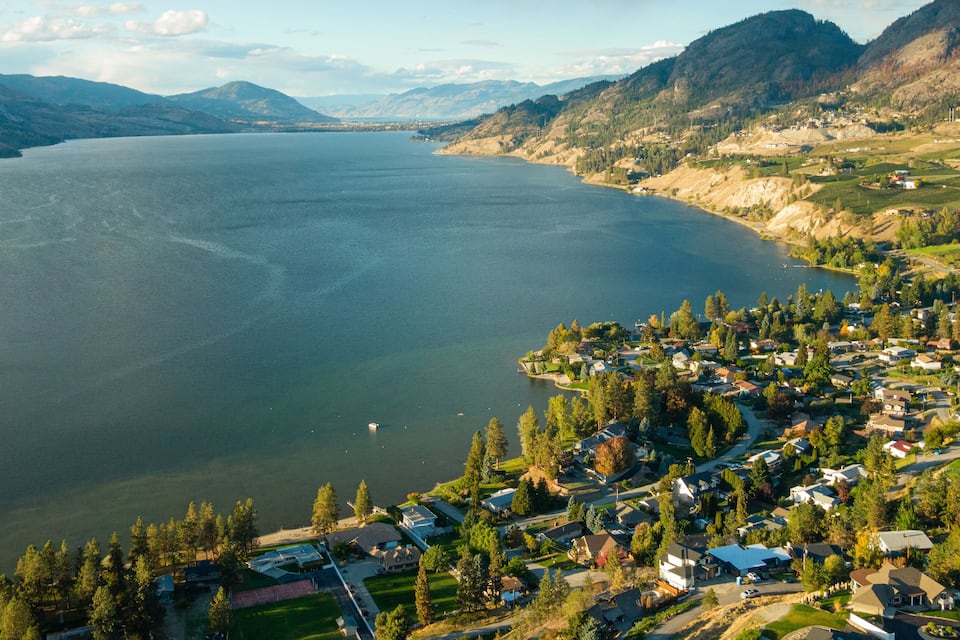 A lake surrounded by mountains and a residential area.