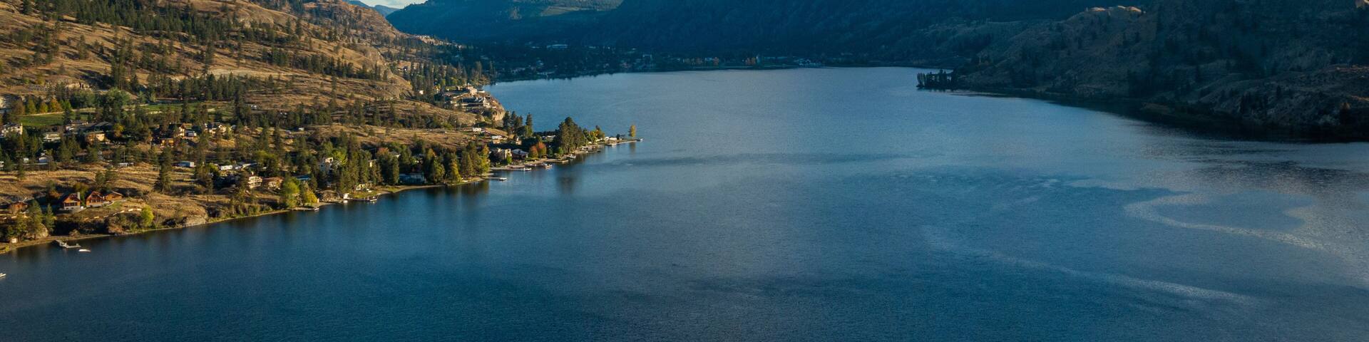 A lake surrounded by mountains and a small town.