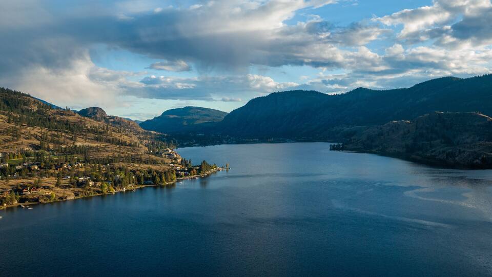 A lake surrounded by mountains and a small town.