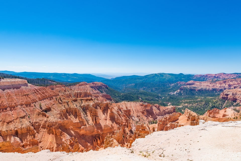 A canyon with layered rock formations and a clear blue sky.