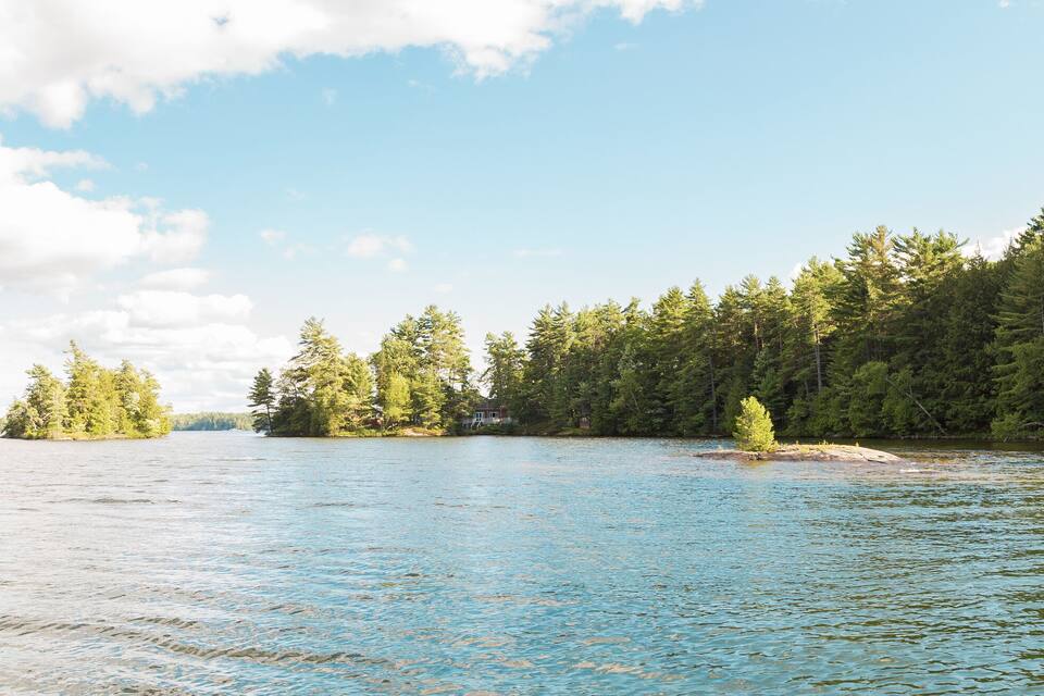 A calm lake surrounded by dense forests and small islands.