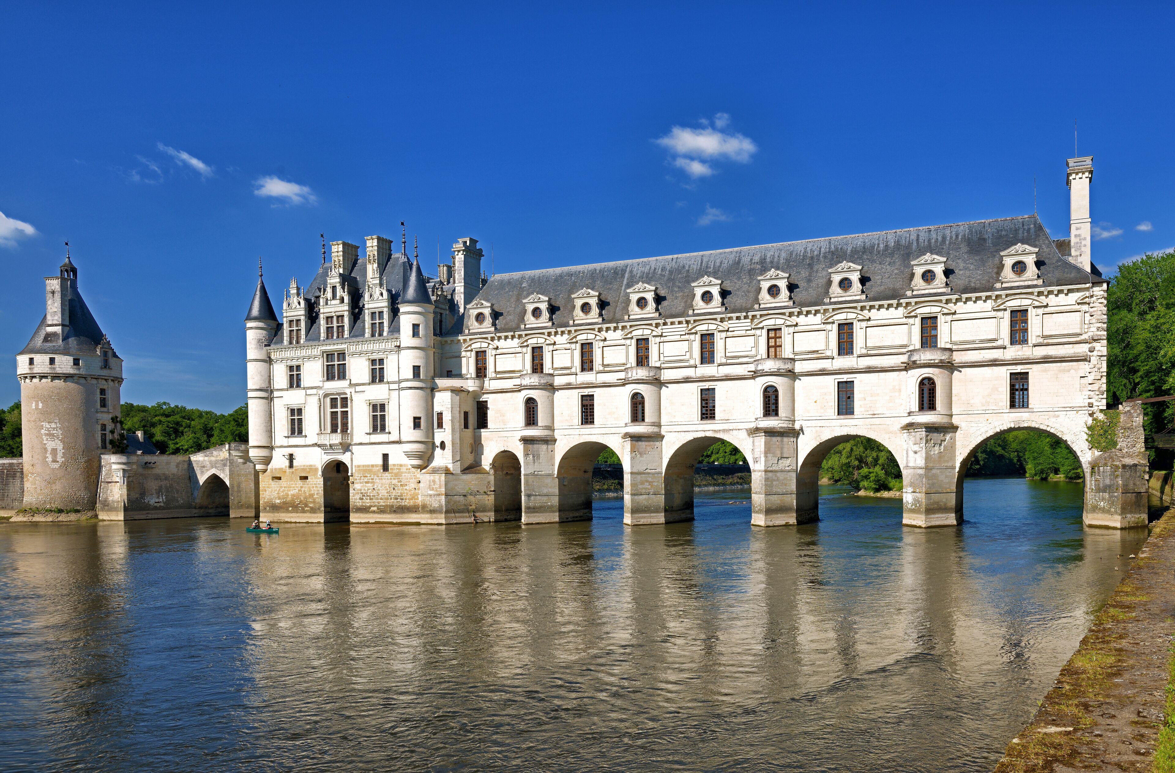 A historic building with a large arched bridge over a river.