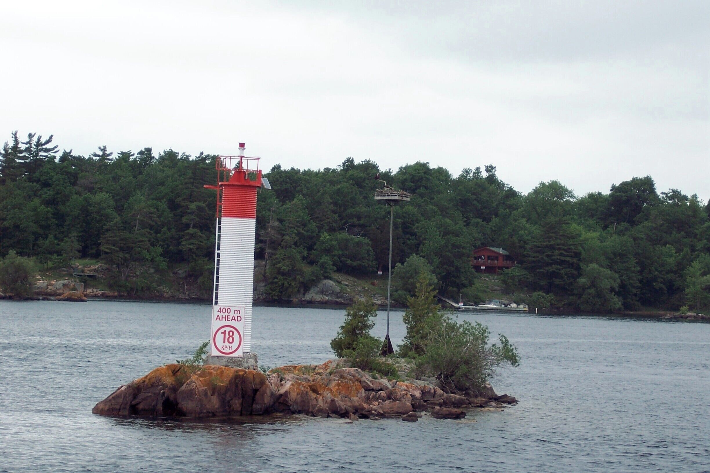 The tiny islands in the St Lawrence River are actually the tops of worn-down mountains. Do the cruise around all the quirky ways that people have added structures to them.  This one is barely a rock let alone an island! #water #boats