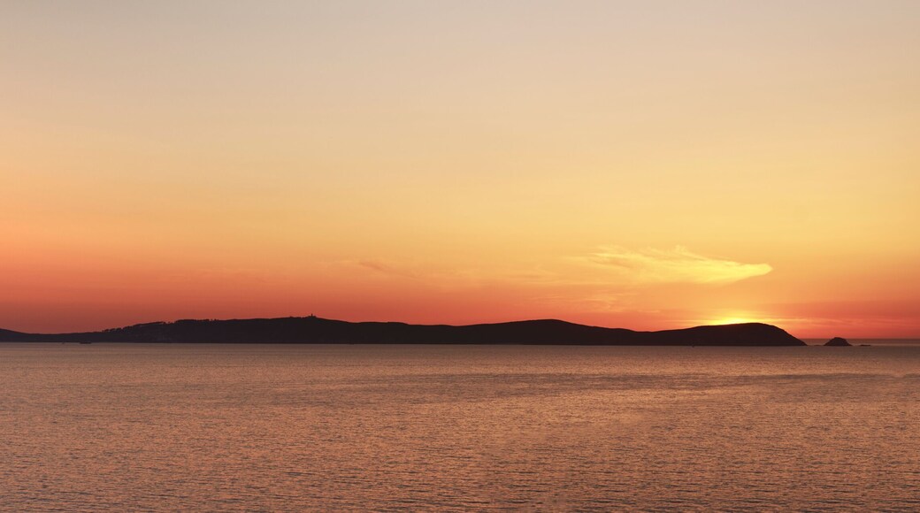 Isla de ons in the ria de pontevedra at sunset with the sun setting just behind
