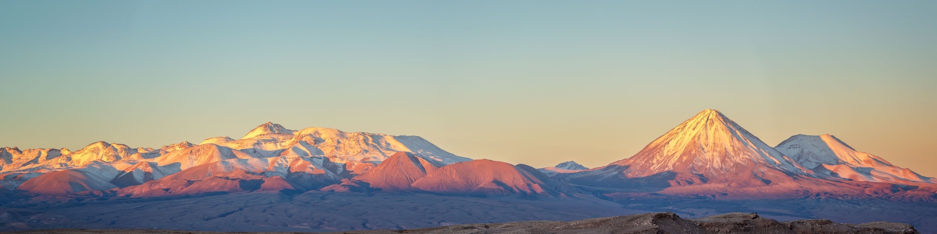 Une chaîne de montagnes dont le sommet se détache particulièrement au coucher du soleil.