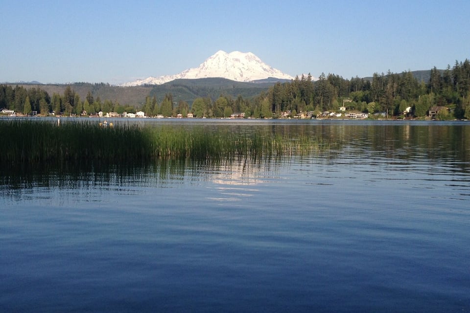 A calm lake with a mountain in the background.