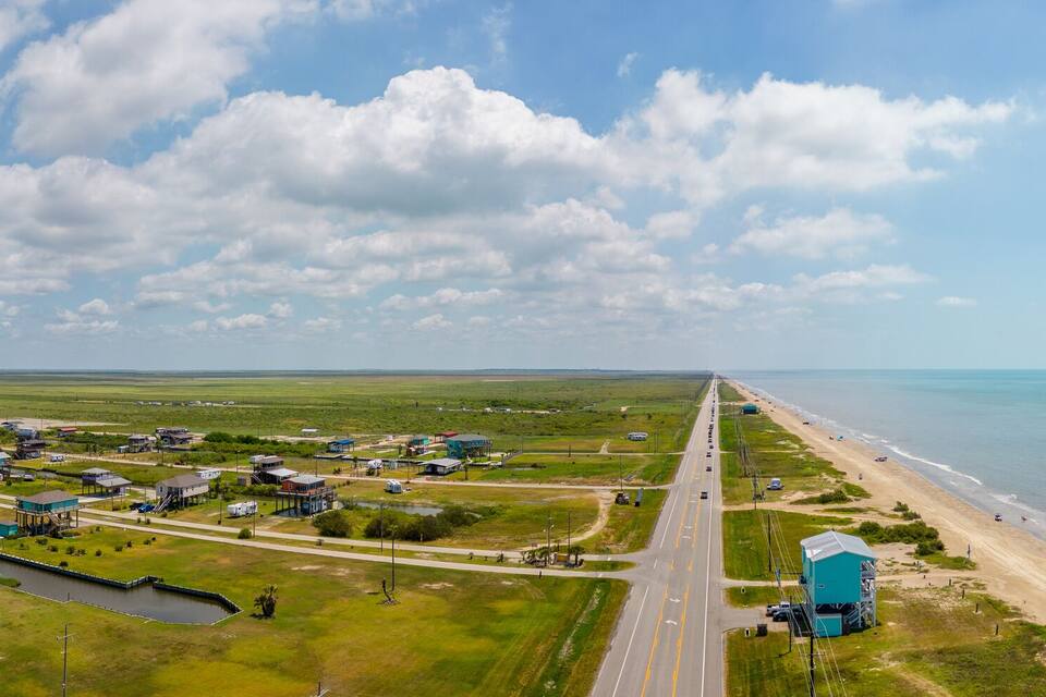 A coastal town with a beach, a river, and a large water tower.