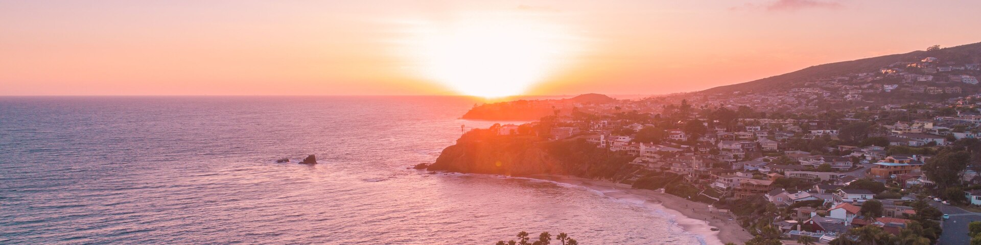 Aerial view over Crescent Bay in Laguna Beach at sunset overlooking Orange County beaches.