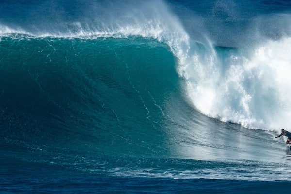 A surfer riding a large wave in the ocean.