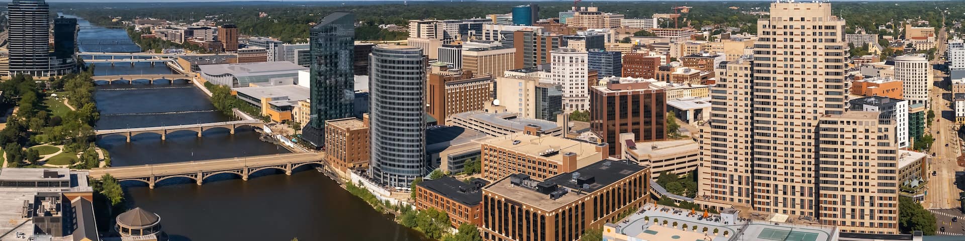 A cityscape with a river, a blue bridge, and various buildings including a large tower.