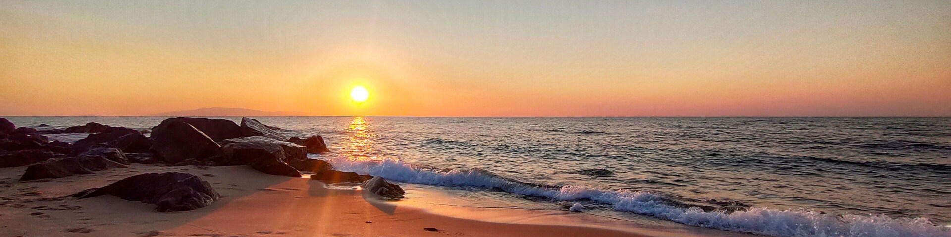 view on the waves crashing on the sandy beach at sunset in El Tarf. Algeria
