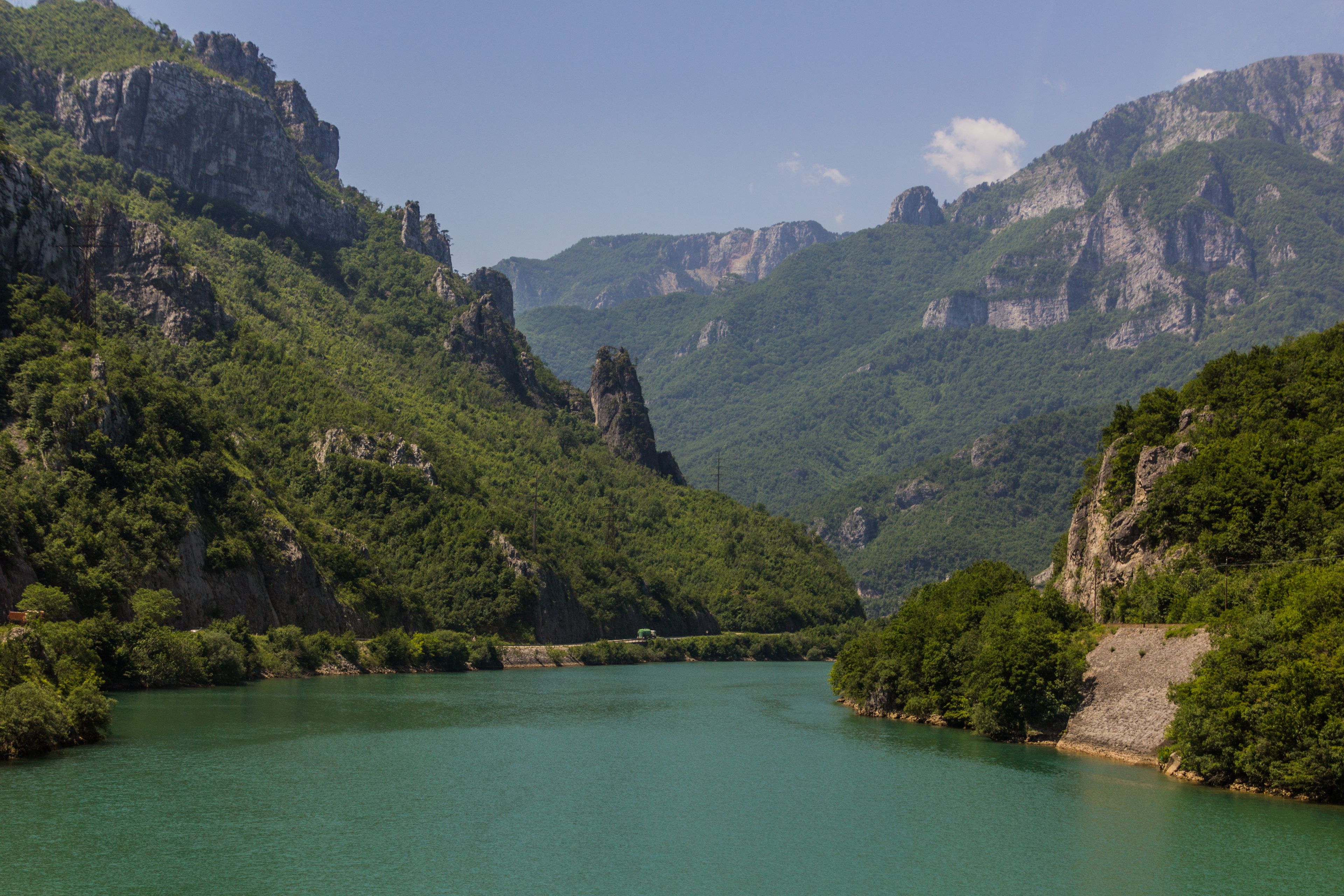 A river winding through a mountainous landscape with dense green forests and rocky cliffs.