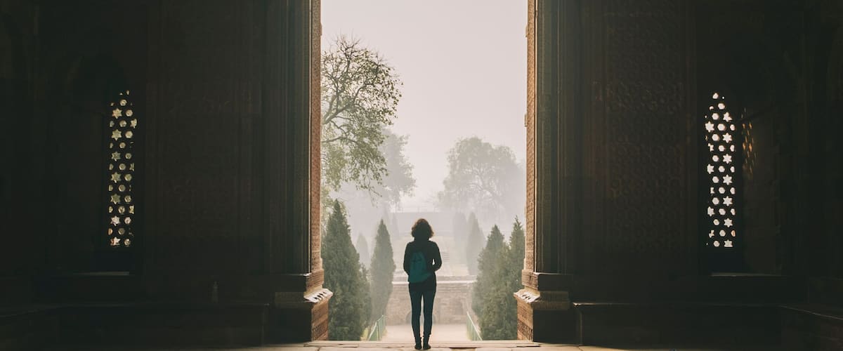 Woman during a foggy sunrise at Qutb complex, New Delhi, India
