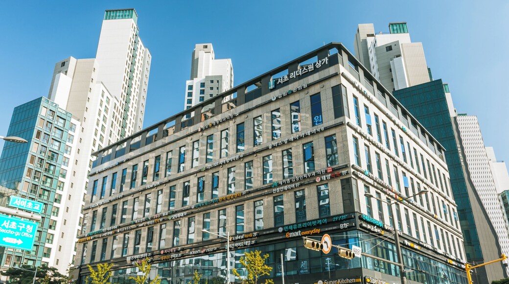 A modern building with multiple floors and large windows, surrounded by other high-rise buildings.