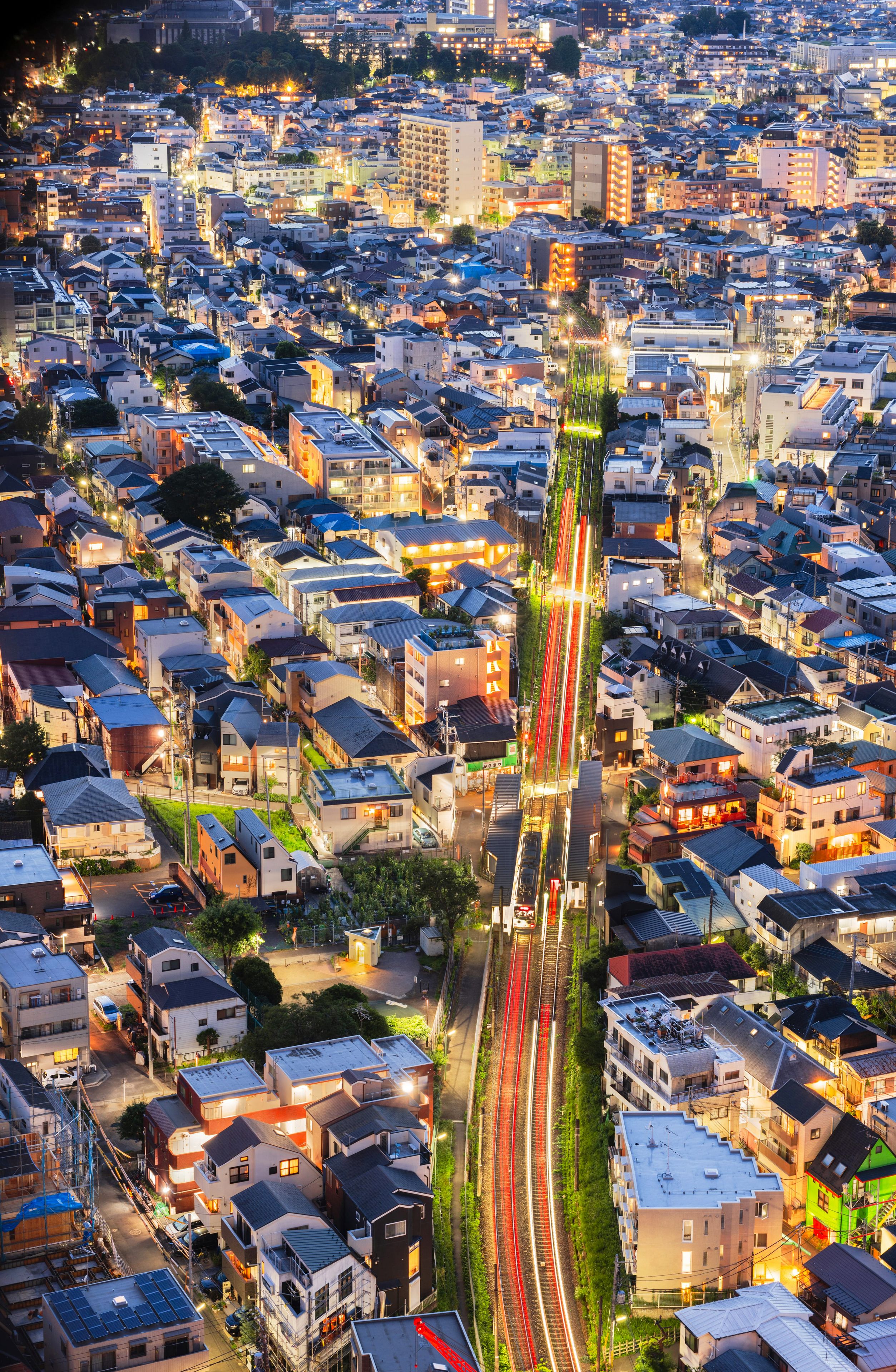 A densely packed urban area with a prominent railway track running through the center, surrounded by residential buildings.