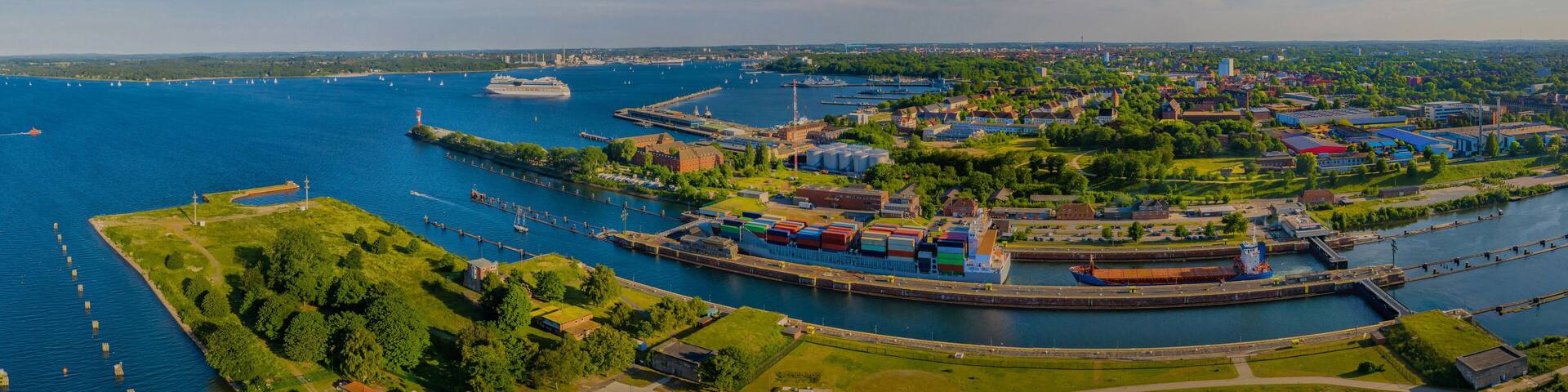 A coastal city with a harbor, ships, and industrial buildings.