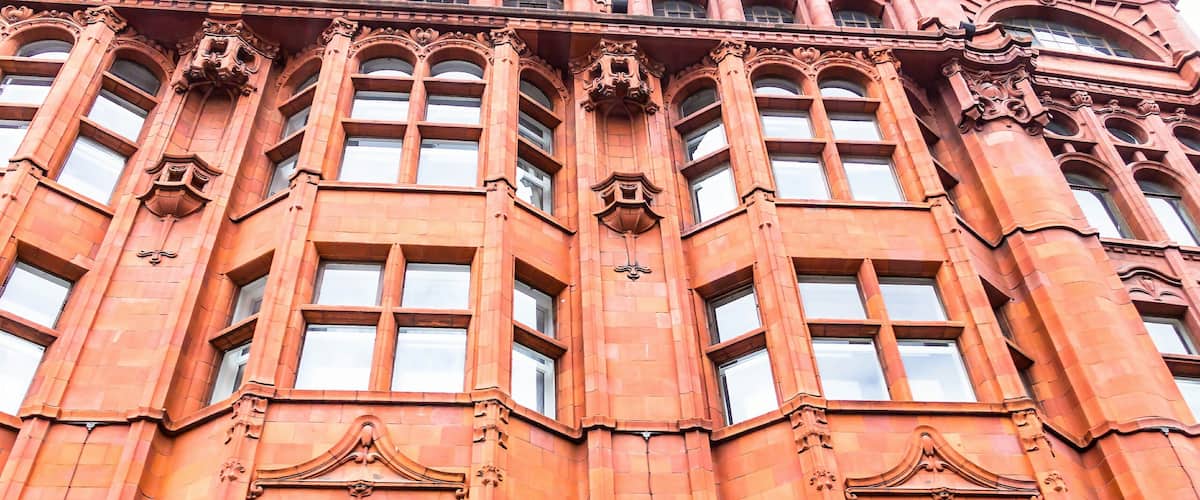 A red brick building with ornate architectural details and multiple windows.
