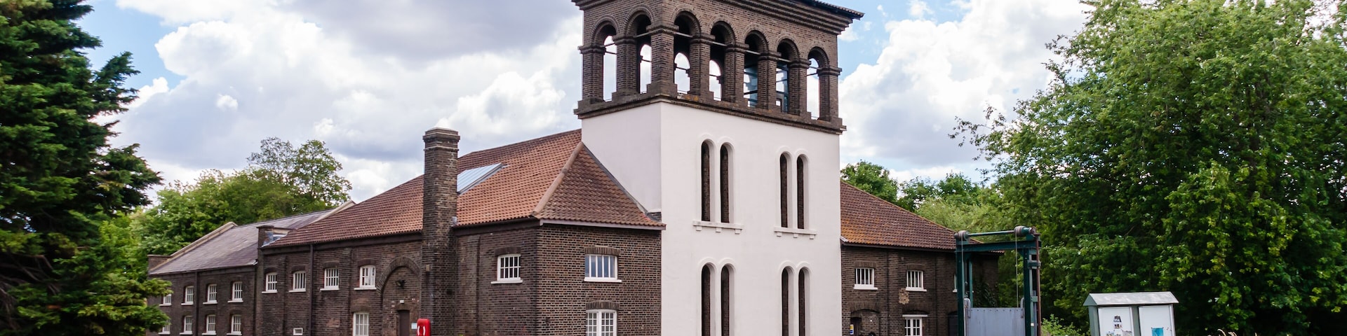 Visitors passing by the Coppermill Tower at Walthamstow Wetlands, Waltham Forest, London, United Kingdom, 3 July 2022