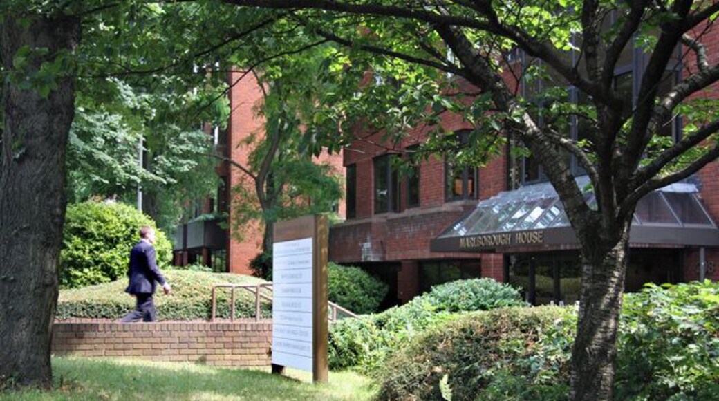 Back from Lunch An office worker returns to Marlborough House in Regents Office Park on Regents Park Road. The sign, just left of centre, lists the companies housed in the building.