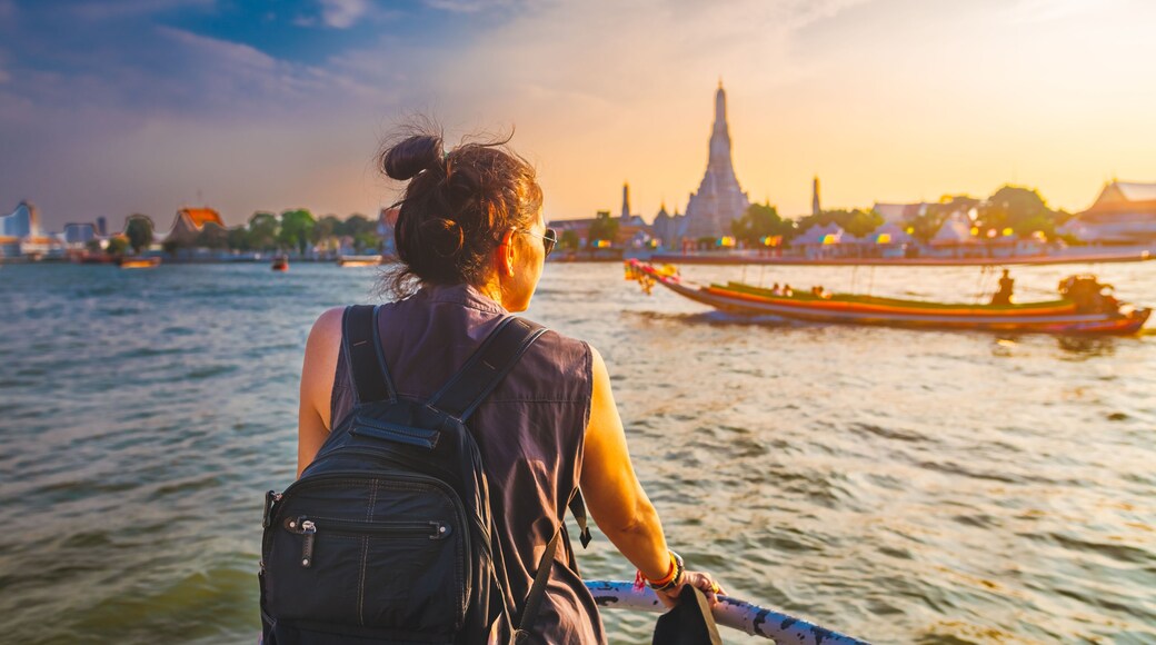 Traveler woman on boat joy view Wat Arun at sunset, Chao Phraya river, Famous water landmark travel Bangkok Thailand, tourist female on holiday vacation trips, Tourism beautiful destination place Asia