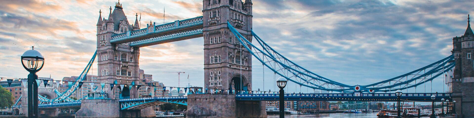 A bridge with two towers and a person walking on a paved path.