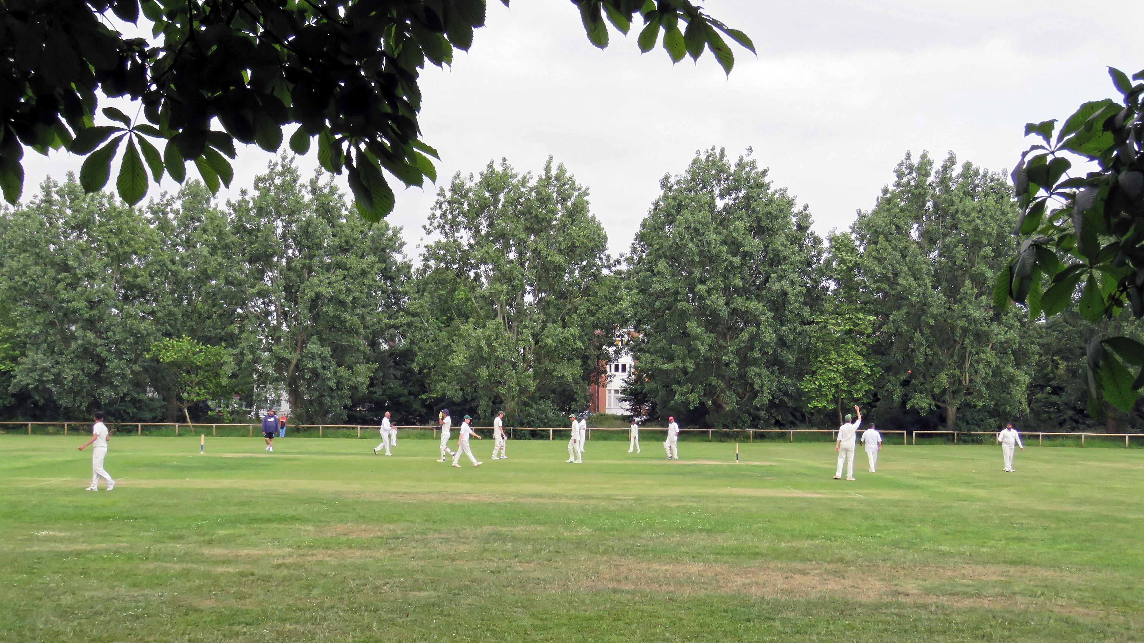 A public Sunday cricket match between Woodford Green CC Sunday 'B' XI and Hackney Marshes CC 1st XI (Hackney batting) at Woodford Green, Woodford, East London, England, in June 2018. Woodford Green CC fields three Saturday teams in the Shepherd Neame Essex League, a Twenty20 team, a Midweek team, two Sunday friendly teams, and seven junior section teams. Camera: Canon PowerShot SX60 HS Software: File lens-corrected, optimized, perhaps cropped, with DxO PhotoLab, and likely further optimized with Adobe Photoshop CS2.