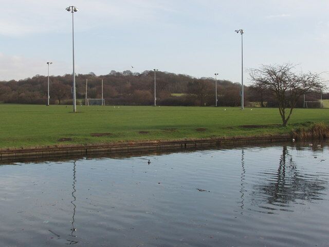 Horsenden Hill, floodlights and playing fields by canal View across the Grand Union Canal to playing fields which include a soccer pitch with floodlights. Horsenden Hill is beyond the lights.