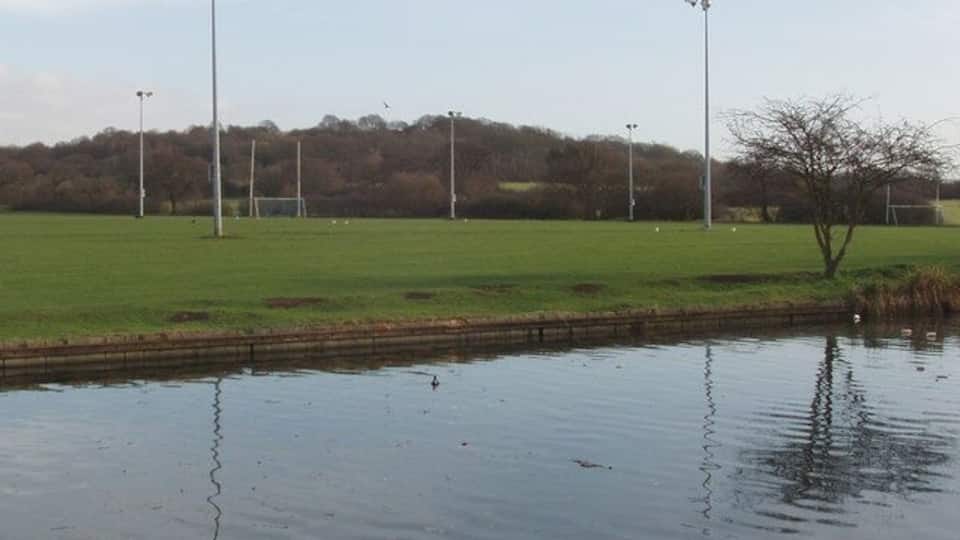 Horsenden Hill, floodlights and playing fields by canal View across the Grand Union Canal to playing fields which include a soccer pitch with floodlights. Horsenden Hill is beyond the lights.
