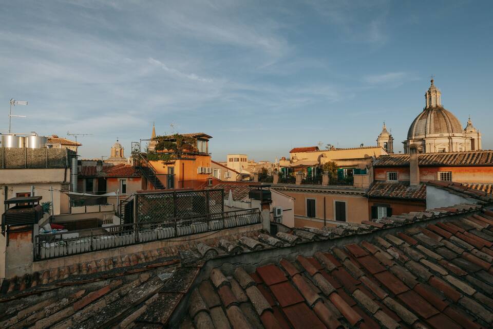 A cityscape with historic buildings, a prominent dome, and terracotta rooftops.