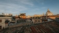 Un paysage urbain avec des bâtiments historiques, un dôme imposant et des toits en tuiles de terre cuite.