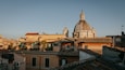 A historic cityscape with a prominent dome and bell tower.