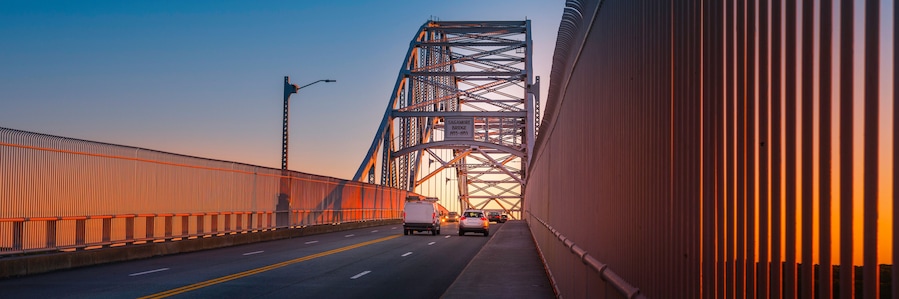 Un puente con estructura metálica y una carretera con vehículos.