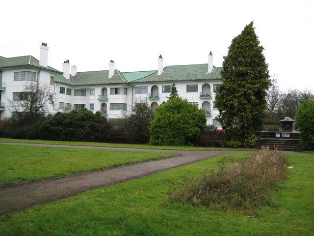 Pinner: Pinner Court, Pinner Road Pinner Court and its sister block, Capel Gardens, were built in 1935 and 1936 as colonial-style luxury flats, for the Courtenay Property Company Limited, to the design of H J Mark. The distinctive green tile roofed white walled buildings have three stories and are arranged in three groupings set back about 60 metres from Pinner Road. The dark block on the right is a fountain.