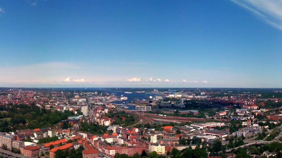 A cityscape with a river, bridges, and a large stadium.