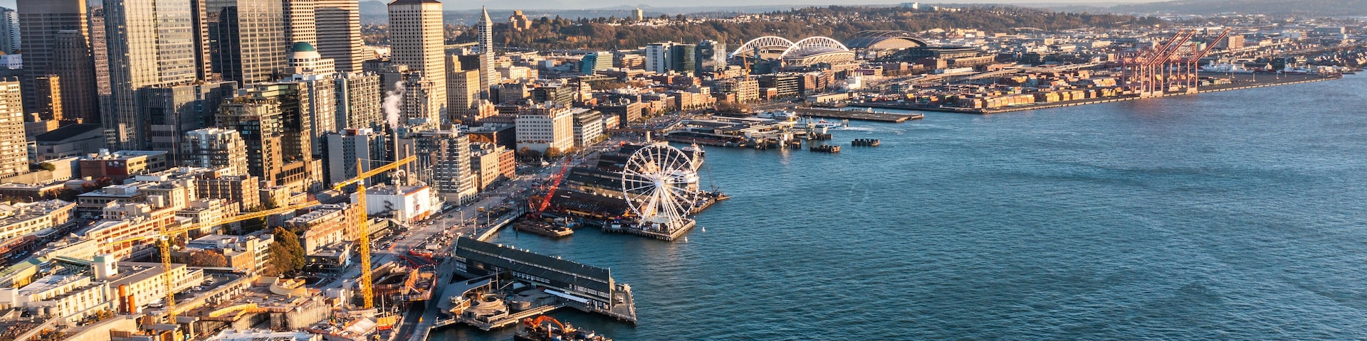 Seattle, Washington, USA - November 2022, aerial view of Seattle Downtown and the Waterfront pier area with The Seattle Great Wheel and Harbour Island with Container Terminal - aerial panoramic view