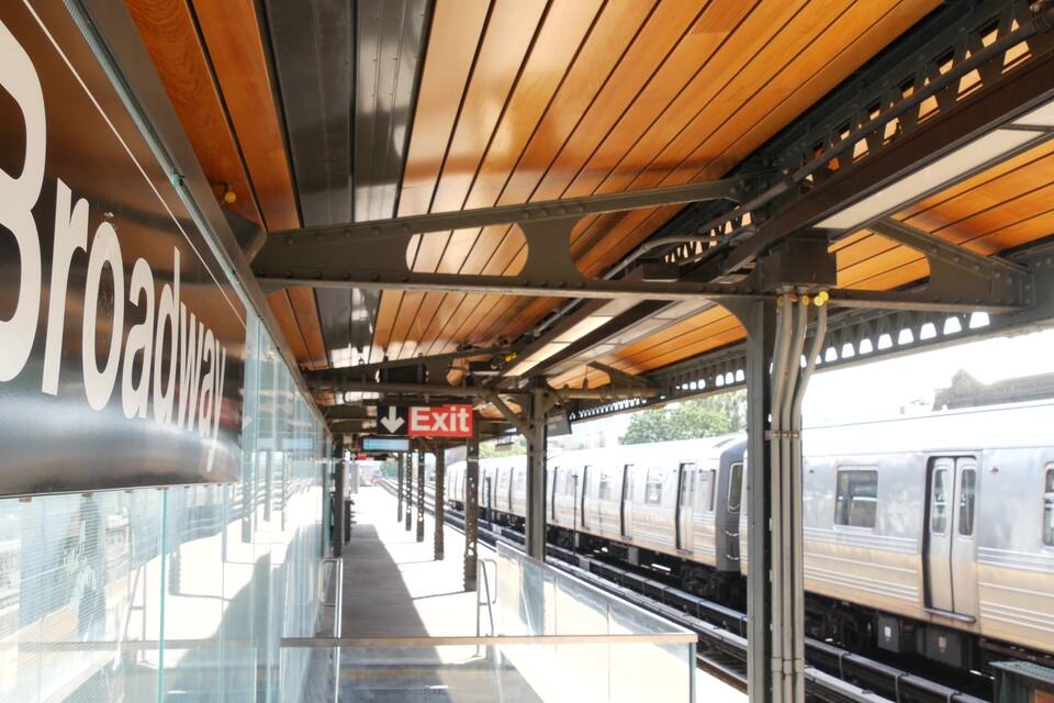 A train station with a wooden ceiling, glass walls, and an 'Exit' sign.