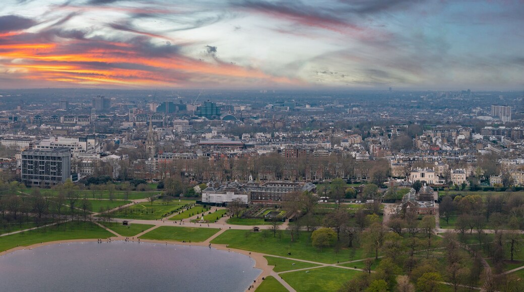 Aerial perspective of Hyde Park with the Serpentine lake, Kensington Palace, and London's cityscape featuring modern and historic architecture.