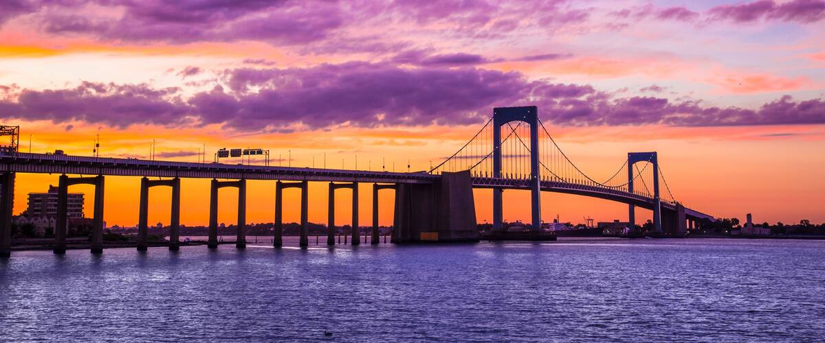 New York City Throgs Neck Bridge from Queens NYC to the Bronx with colorful sunset sky