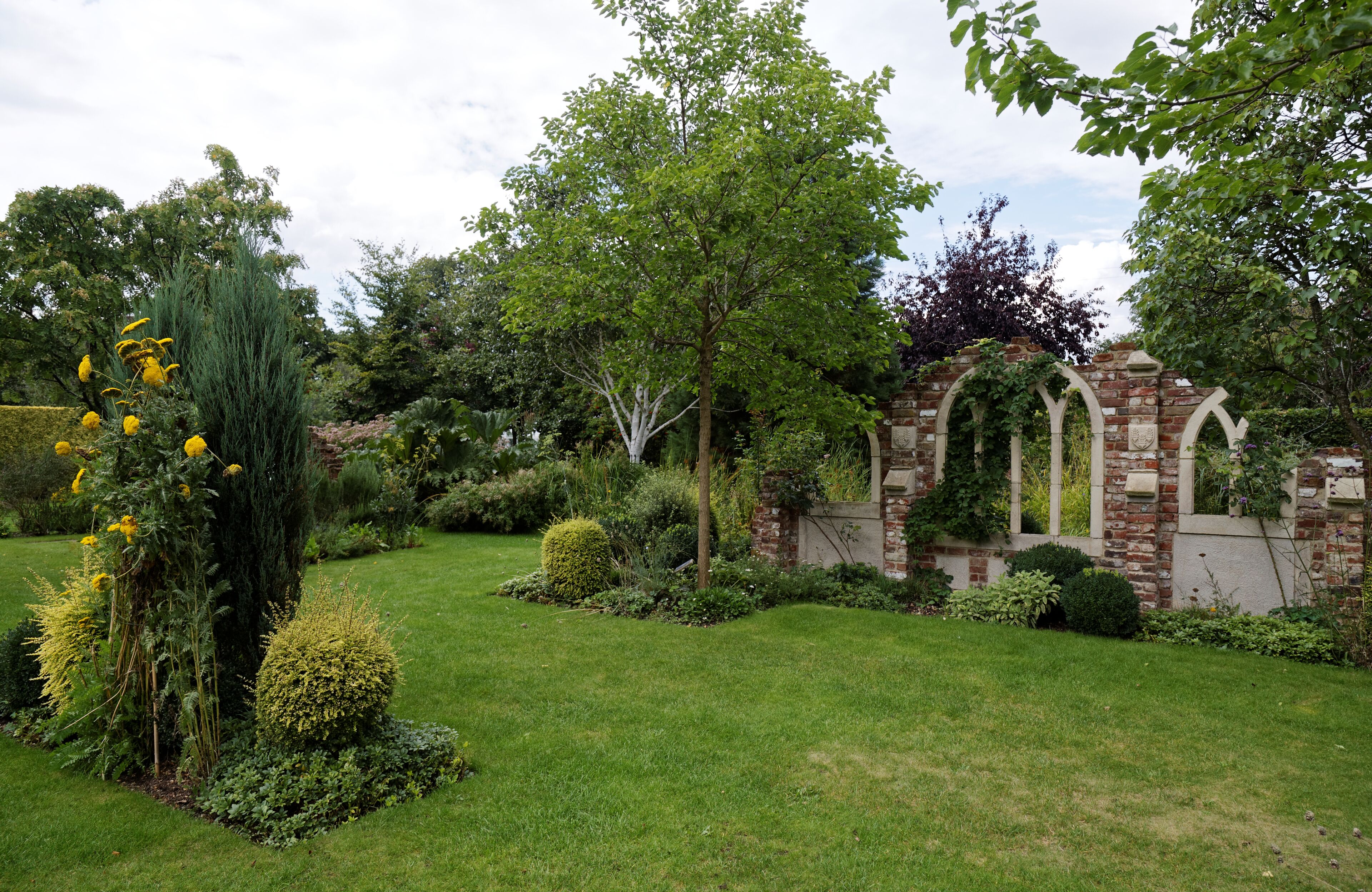 Borders ruins and lawn in the 'Old Manor House Garden' folly at Capel Manor College and Gardens, Bulls Cross, Enfield, London, England. Software: RAW file lens-corrected, optimized and converted to JPEG with DxO OpticsPro 10 Elite, and likely further optimized and/or cropped and/or spun with Adobe Photoshop CS2.