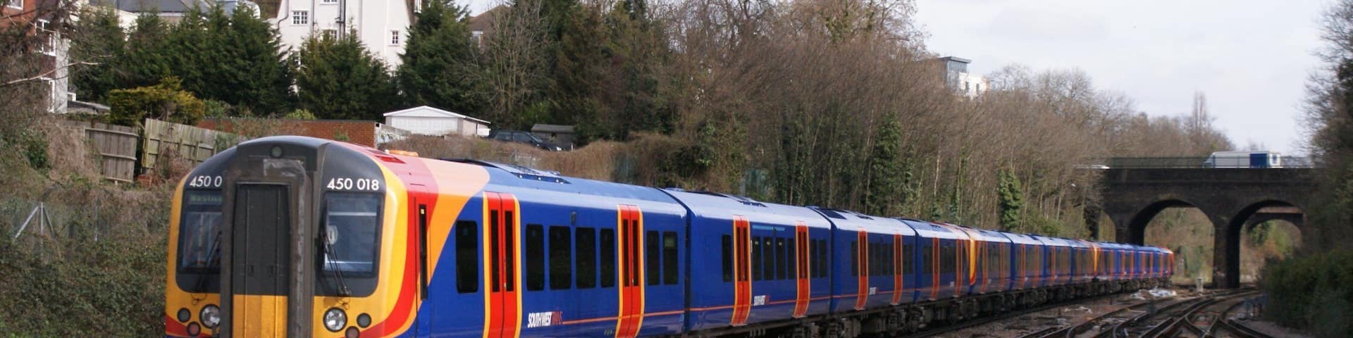 Siemens (Wein & Uerdingen) Class 450 "Desiro" 750 v dc 3rd rail 4-car emu No.450 018 of South West Trains in SWT outer-suburban livery speeds through Surbiton on a Waterloo - Basingstoke service, 03/09.