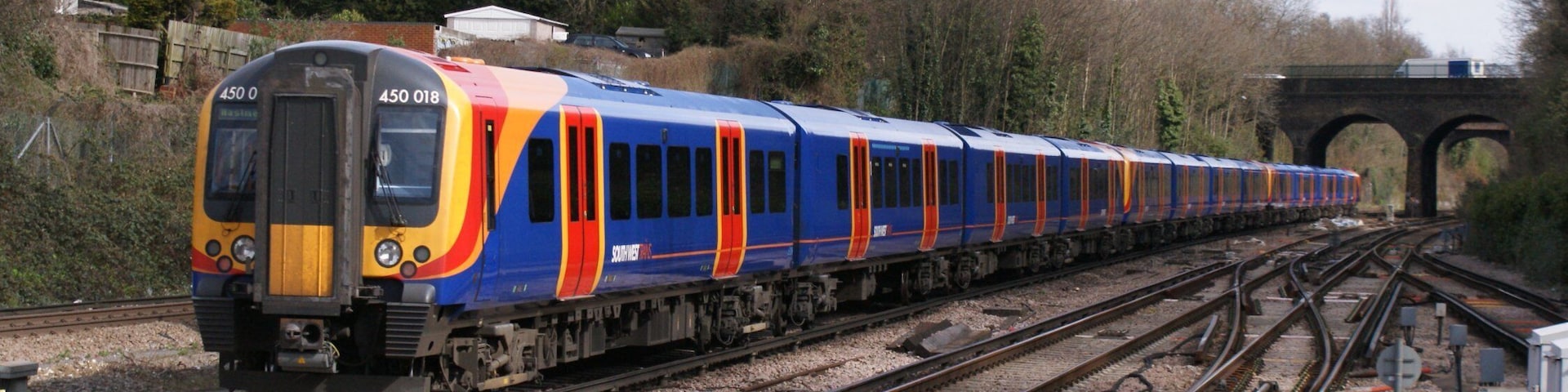 Siemens (Wein & Uerdingen) Class 450 "Desiro" 750 v dc 3rd rail 4-car emu No.450 018 of South West Trains in SWT outer-suburban livery speeds through Surbiton on a Waterloo - Basingstoke service, 03/09.