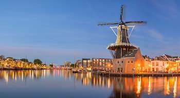 Windmill de adriaan and cityscape reflections on spaarne river in haarlem, netherlands