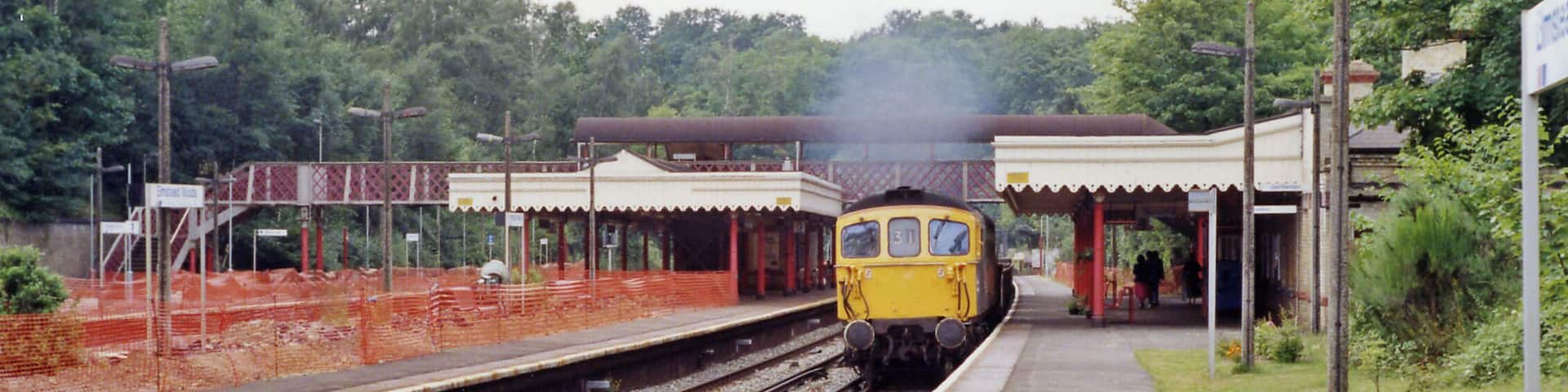 Elmstead Woods station, 1991. View NW, towards London: ex-SE&CR Charing Cross/Cannon Street - Orpington, Sevenoaks, Tonbridge, Ashford etc.. Work is evidently under way on the station and a Class 33 Diesel approaches on a Down Engineer's train.