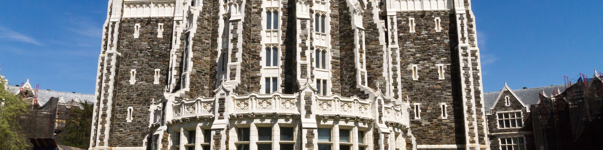 A large, ornate stone building with multiple towers and arched windows.
